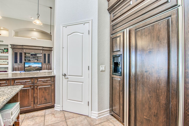 1348 Franklin Wind Place, El Paso, TX 79912 - kitchen featuring a textured wall, light tile patterned floors, light stone countertops, and dark brown cabinets