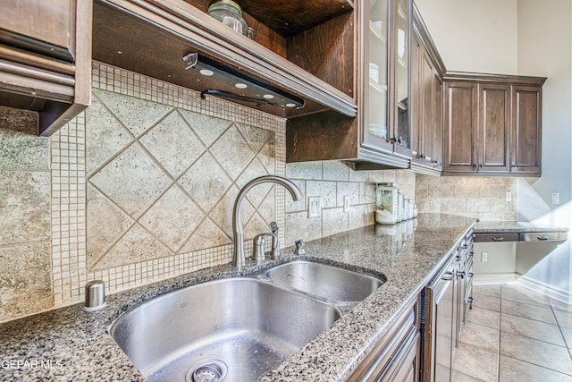 1348 Franklin Wind Place, El Paso, TX 79912 - kitchen with dark brown cabinets, light stone countertops, tasteful backsplash, glass insert cabinets, and extractor fan