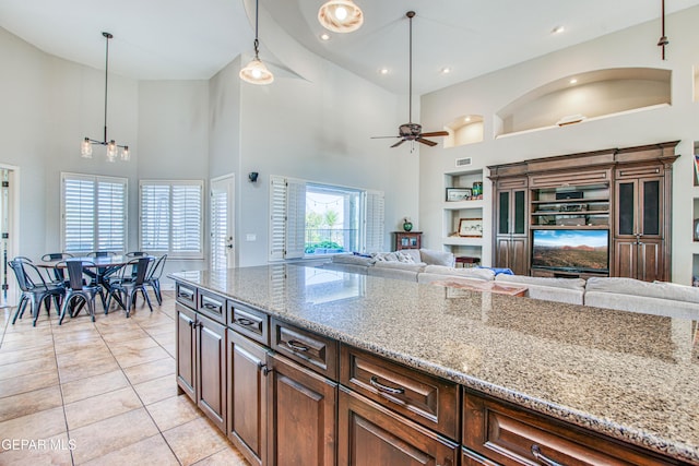 1348 Franklin Wind Place, El Paso, TX 79912 - kitchen with built in shelves, a high ceiling, a ceiling fan, recessed lighting, and light stone countertops