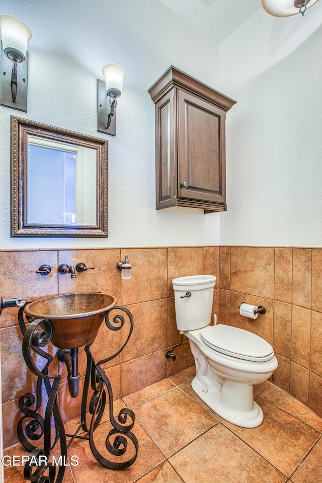 1348 Franklin Wind Place, El Paso, TX 79912 - bathroom with tile walls, tile patterned floors, and a wainscoted wall