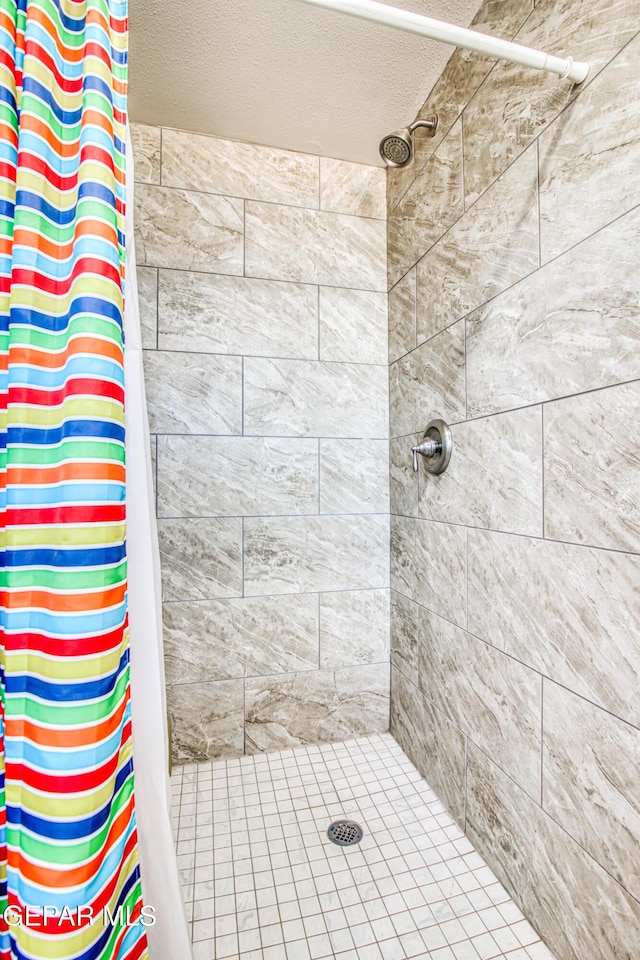 1348 Franklin Wind Place, El Paso, TX 79912 - bathroom featuring tiled shower and a textured ceiling