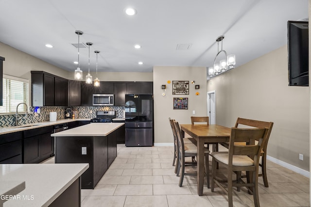 3448 David Palacio Dr, El Paso, TX 79938 - kitchen with appliances with stainless steel finishes, backsplash, light countertops, light tile patterned floors, and a center island