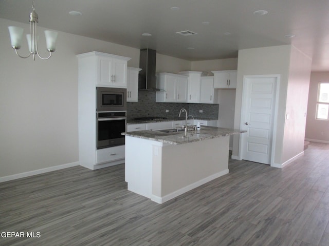 205 Staffs Way, El Paso, TX 79928 - kitchen with wall chimney range hood, stainless steel appliances, backsplash, and white cabinetry