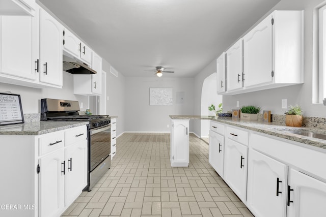 8936 Mount Rushmore Ln, El Paso, TX 79904 - kitchen featuring gas range, under cabinet range hood, a ceiling fan, white cabinets, and brick patterned floors
