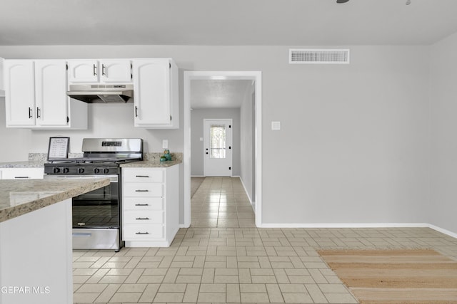 8936 Mount Rushmore Ln, El Paso, TX 79904 - kitchen with gas range, under cabinet range hood, white cabinetry, light stone counters, and light tile patterned flooring
