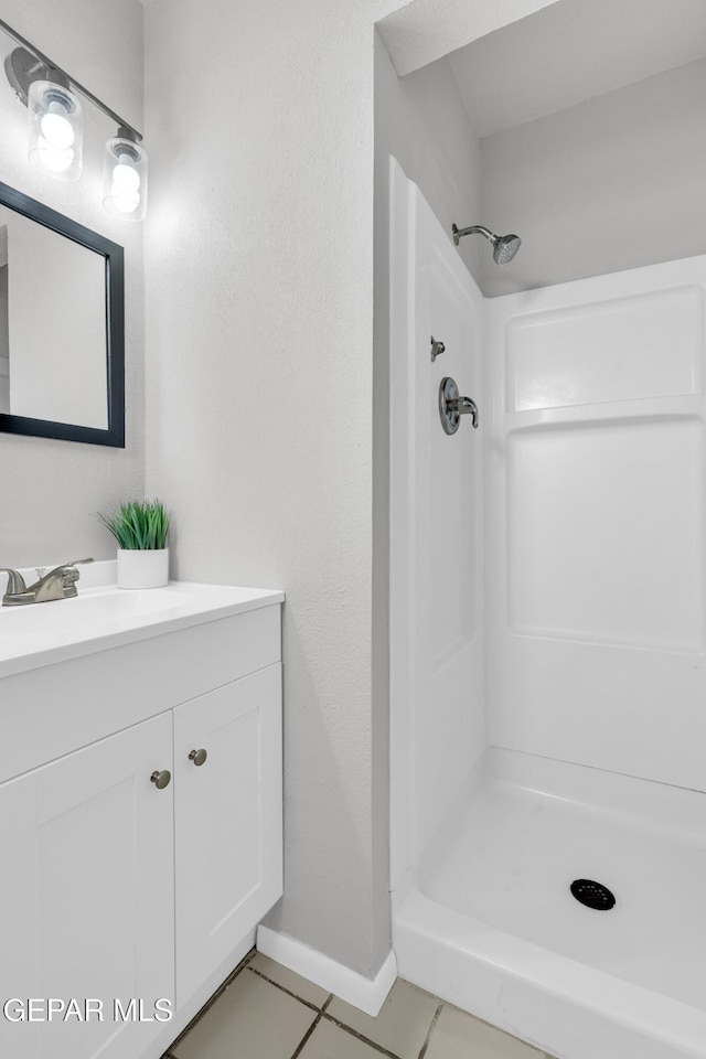 8936 Mount Rushmore Ln, El Paso, TX 79904 - full bath featuring vanity, a shower stall, and tile patterned flooring