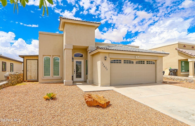 13675 Everingham St, El Paso, TX 79928 - view of front of property featuring a tiled roof, stucco siding, concrete driveway, and an attached garage