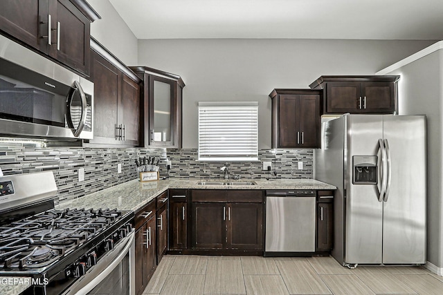 13675 Everingham St, El Paso, TX 79928 - kitchen with stainless steel appliances, decorative backsplash, light stone counters, and dark brown cabinetry