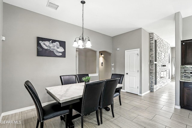 13675 Everingham St, El Paso, TX 79928 - dining space featuring a chandelier, arched walkways, and wood tiled floors