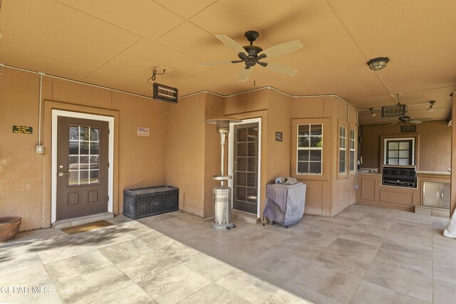 658 Sara Lynn Ct, El Paso, TX 79932 - property entrance with ceiling fan, a patio, an outdoor kitchen, and stucco siding