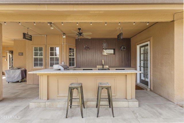 658 Sara Lynn Ct, El Paso, TX 79932 - kitchen with track lighting, wood walls, a large island, a textured wall, and open floor plan