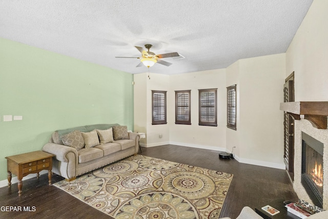 658 Sara Lynn Ct, El Paso, TX 79932 - living room with a warm lit fireplace, wood finished floors, ceiling fan, and a textured ceiling