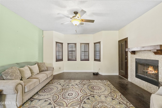 658 Sara Lynn Ct, El Paso, TX 79932 - living room featuring wood finished floors, ceiling fan, a tiled fireplace, and a textured ceiling