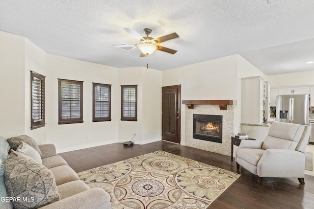 658 Sara Lynn Ct, El Paso, TX 79932 - living room with dark wood-style flooring, a ceiling fan, a fireplace, and a textured ceiling