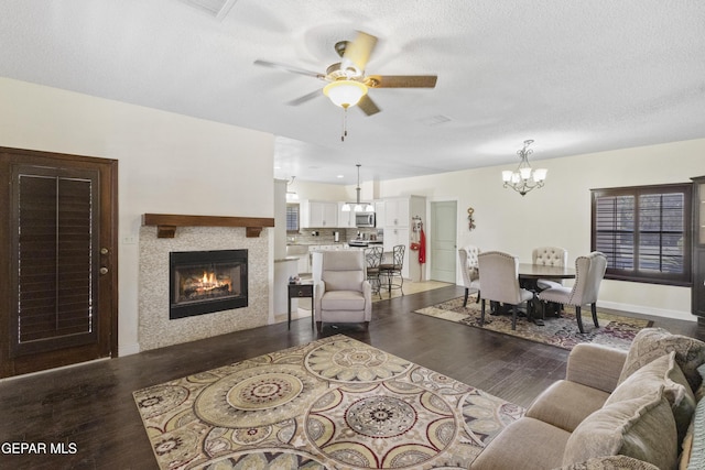 658 Sara Lynn Ct, El Paso, TX 79932 - living room featuring a chandelier, a tiled fireplace, wood finished floors, a ceiling fan, and a textured ceiling