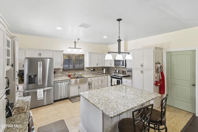 658 Sara Lynn Ct, El Paso, TX 79932 - kitchen with appliances with stainless steel finishes, backsplash, a kitchen bar, a kitchen island, and recessed lighting