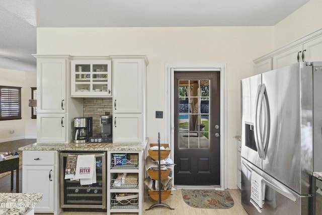 658 Sara Lynn Ct, El Paso, TX 79932 - kitchen with stainless steel fridge, beverage cooler, light stone countertops, white cabinetry, and glass insert cabinets