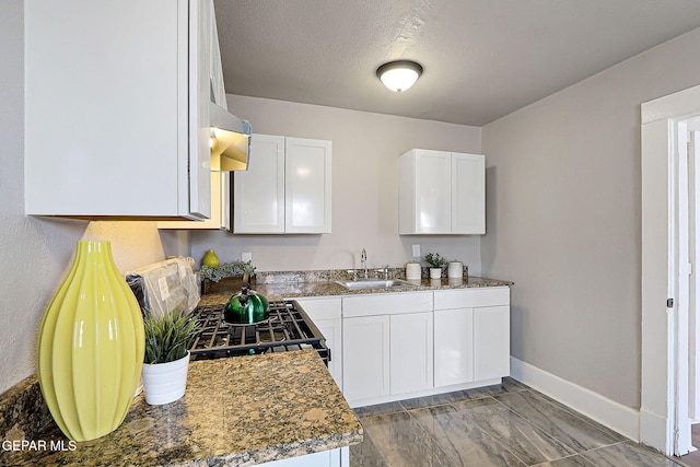3413 Monroe Ave, El Paso, TX 79930 - kitchen with white cabinetry, marble finish flooring, dark countertops, and extractor fan