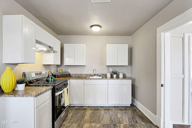 3413 Monroe Ave, El Paso, TX 79930 - kitchen with stainless steel gas range oven, under cabinet range hood, white cabinets, dark stone counters, and a textured ceiling