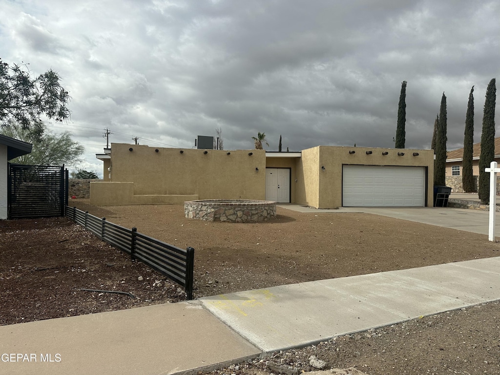 836 De Leon Dr, El Paso, TX 79912 - pueblo-style house featuring driveway, stucco siding, and an attached garage