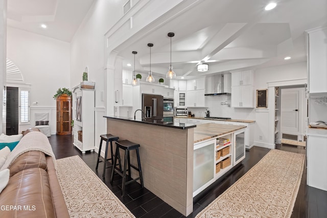 1386 Loma Verde Dr, El Paso, TX 79936 - kitchen with wall chimney range hood, open floor plan, stainless steel appliances, recessed lighting, and white cabinets