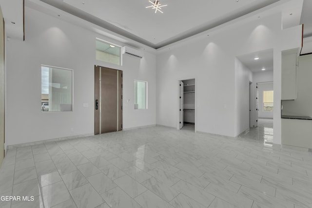 11345 Patricia Ave, El Paso, TX 79936 - empty room featuring plenty of natural light, a wall mounted air conditioner, a high ceiling, and light marble finish flooring