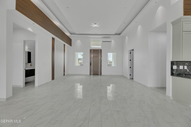 11345 Patricia Ave, El Paso, TX 79936 - spare room featuring elevator, a raised ceiling, an AC wall unit, and light marble finish flooring