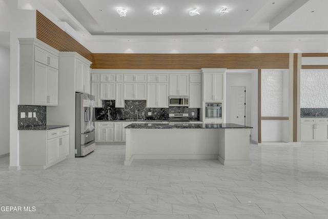 11345 Patricia Ave, El Paso, TX 79936 - kitchen with stainless steel appliances, tasteful backsplash, white cabinetry, light marble finish flooring, and a center island
