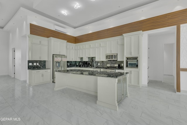 11345 Patricia Ave, El Paso, TX 79936 - kitchen with appliances with stainless steel finishes, a kitchen island, white cabinets, a high ceiling, and tasteful backsplash