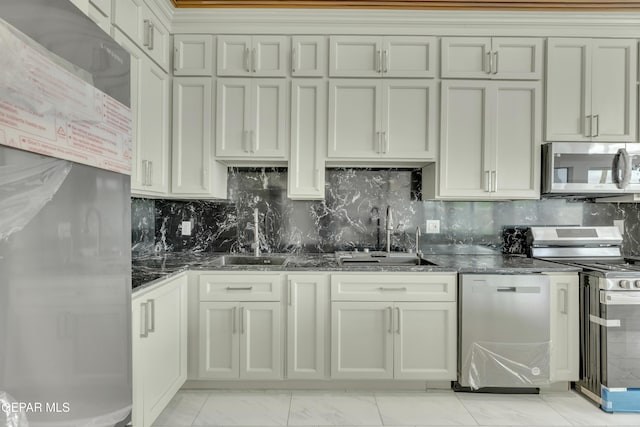 11345 Patricia Ave, El Paso, TX 79936 - kitchen with appliances with stainless steel finishes, light marble finish flooring, dark stone counters, and decorative backsplash