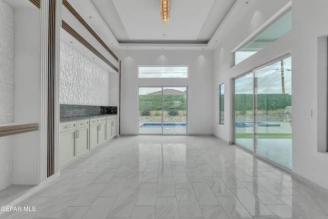 11345 Patricia Ave, El Paso, TX 79936 - unfurnished room featuring a towering ceiling, light marble finish flooring, and a tray ceiling