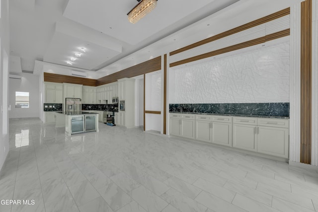 11345 Patricia Ave, El Paso, TX 79936 - kitchen with stainless steel fridge with ice dispenser, decorative backsplash, white cabinets, a kitchen island, and open floor plan
