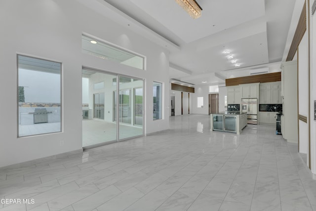 11345 Patricia Ave, El Paso, TX 79936 - unfurnished living room featuring a towering ceiling and light marble finish floors