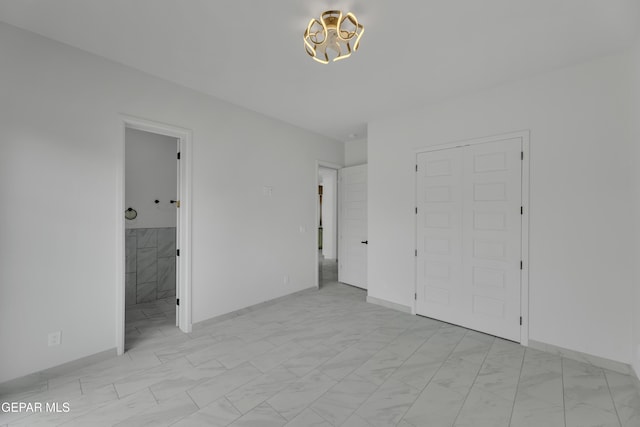 11345 Patricia Ave, El Paso, TX 79936 - unfurnished bedroom featuring light marble finish floors, a chandelier, and ensuite bath