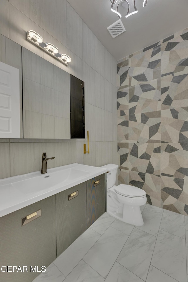 11345 Patricia Ave, El Paso, TX 79936 - bathroom with tile walls, vanity, and marble finish floors