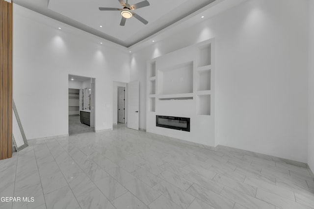 11345 Patricia Ave, El Paso, TX 79936 - unfurnished living room featuring ceiling fan, a glass covered fireplace, light marble finish floors, a towering ceiling, and recessed lighting