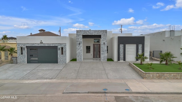 11345 Patricia Ave, El Paso, TX 79936 - modern home featuring a garage, stone siding, stucco siding, and driveway