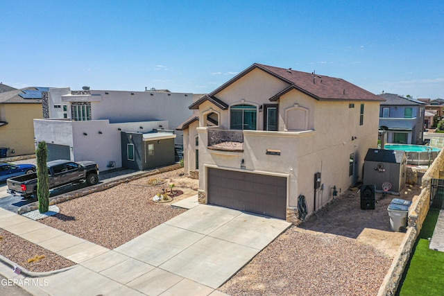 12616 Blazing Star Dr, El Paso, TX 79928 - view of front facade with stucco siding, concrete driveway, an attached garage, a balcony, and a residential view