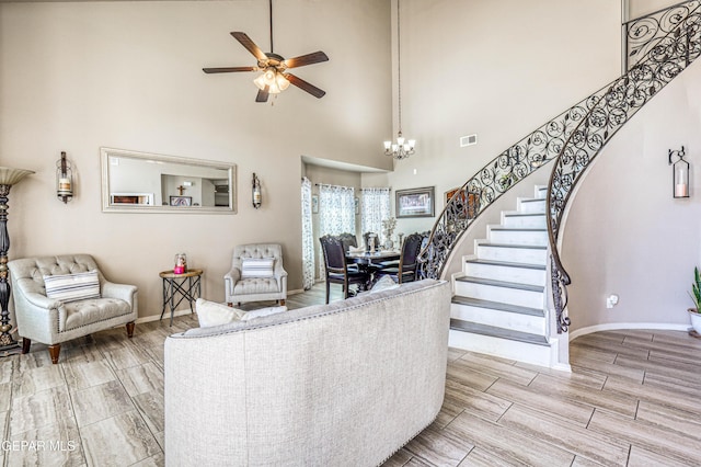 12616 Blazing Star Dr, El Paso, TX 79928 - living room with stairs, ceiling fan, a high ceiling, wood finish floors, and a chandelier