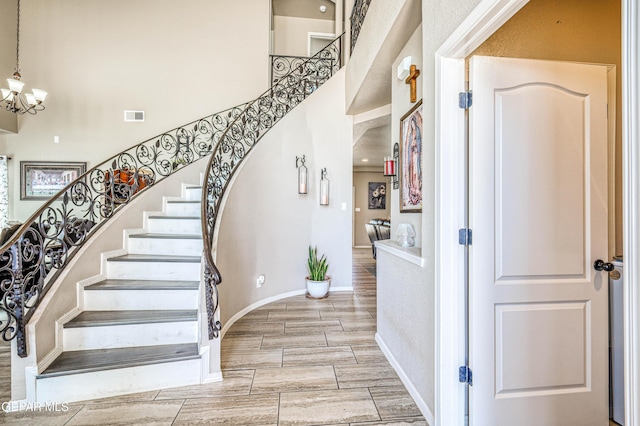12616 Blazing Star Dr, El Paso, TX 79928 - stairs featuring a towering ceiling, a chandelier, and wood finish floors