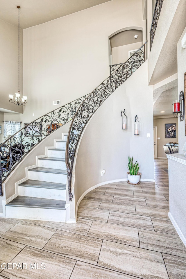 12616 Blazing Star Dr, El Paso, TX 79928 - stairs with a towering ceiling, a chandelier, and wood finish floors