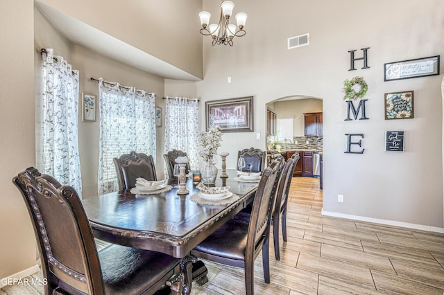 12616 Blazing Star Dr, El Paso, TX 79928 - dining space featuring arched walkways, wood tiled floors, and a chandelier
