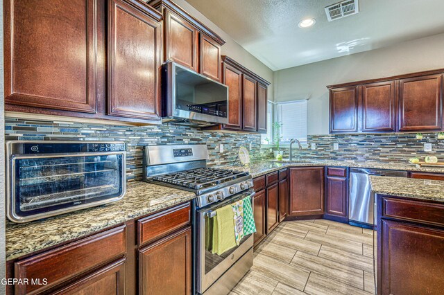 12616 Blazing Star Dr, El Paso, TX 79928 - kitchen featuring stainless steel appliances, light stone countertops, backsplash, and recessed lighting