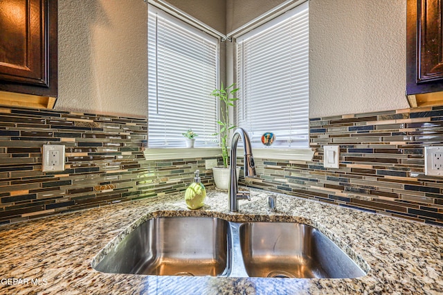 12616 Blazing Star Dr, El Paso, TX 79928 - kitchen view of a textured wall, decorative backsplash, dark brown cabinetry, and light stone counters