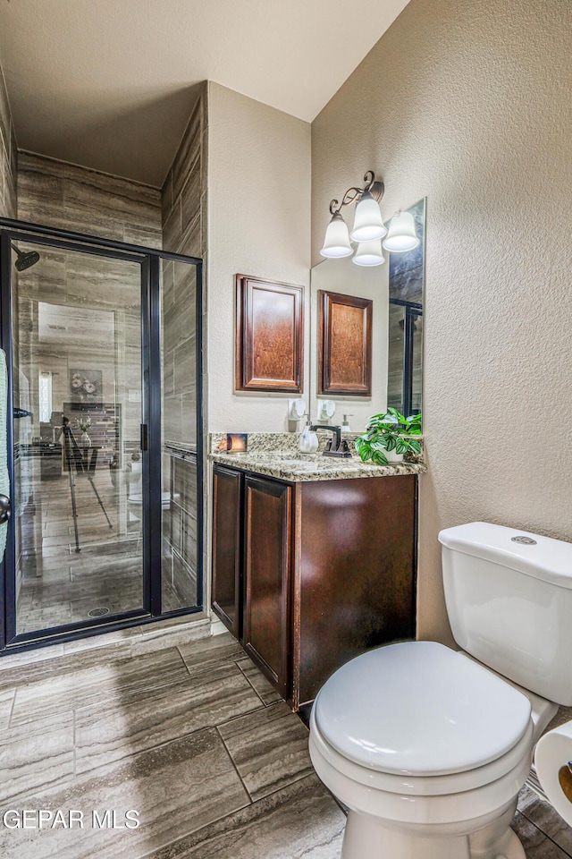12616 Blazing Star Dr, El Paso, TX 79928 - bathroom featuring vanity, a shower stall, a textured wall, and wood finished floors