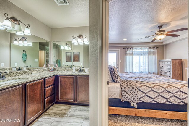 12616 Blazing Star Dr, El Paso, TX 79928 - full bathroom with connected bathroom, double vanity, a textured ceiling, and a ceiling fan