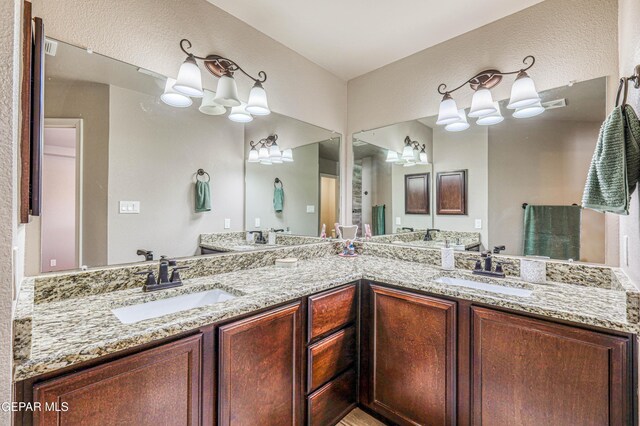 12616 Blazing Star Dr, El Paso, TX 79928 - bathroom featuring a chandelier, double vanity, and a textured wall