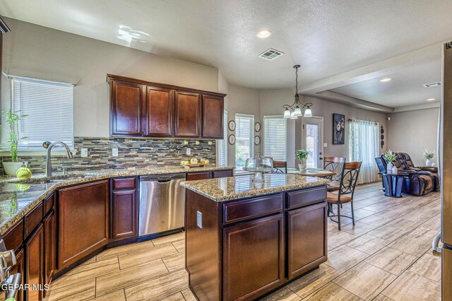 12616 Blazing Star Dr, El Paso, TX 79928 - kitchen with stainless steel dishwasher, decorative backsplash, light stone countertops, wood tiled floors, and a center island