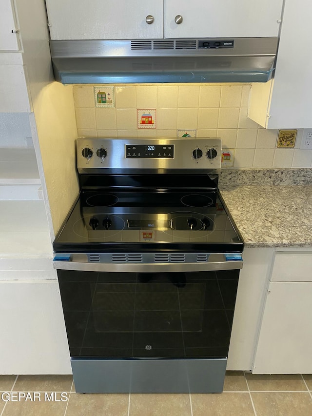 5109 Yvette Ave, El Paso, TX 79924 - kitchen with stainless steel electric range, under cabinet range hood, tasteful backsplash, light tile patterned floors, and light stone countertops