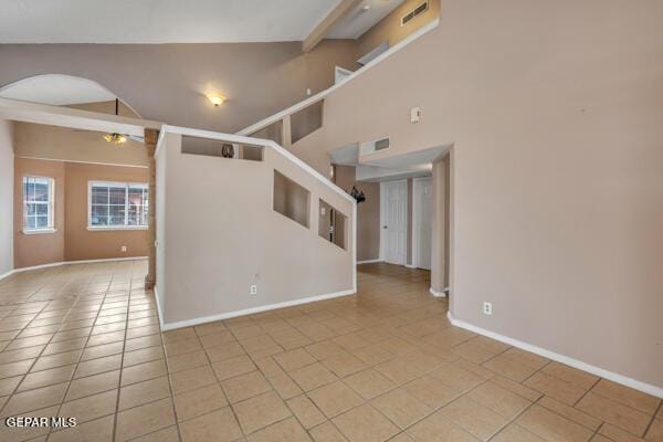 9813 La Morenita Cir, El Paso, TX 79927 - empty room with arched walkways, light tile patterned flooring, high vaulted ceiling, and beamed ceiling